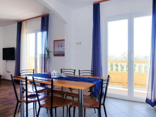 a dining room with a blue table and chairs at Apartment Dora - RAB142 by Interhome in Rab