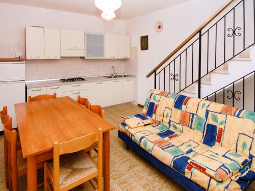 eine Küche und ein Esszimmer mit einem Sofa und einem Tisch in der Unterkunft Apartment Casa Lucrezia-1 by Interhome in Rosolina Mare