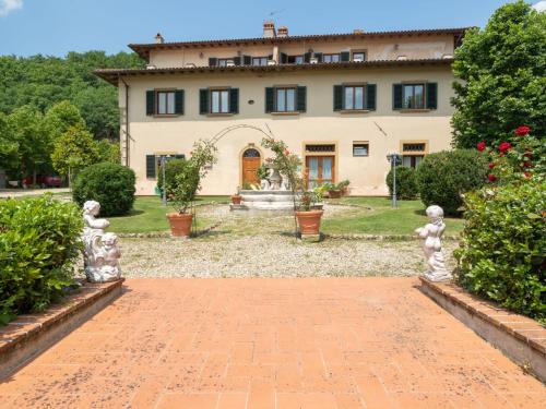 a house with a garden with statues in front of it at Apartment Vigna La Corte-5 by Interhome in Dicomano