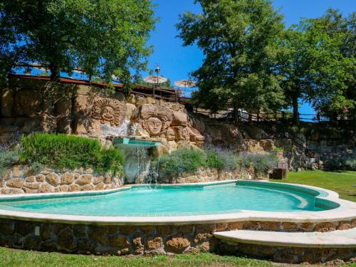 a swimming pool with a waterfall in a park at Apartment Oak-3 by Interhome in Sorano