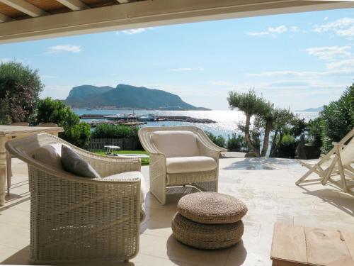 patio con sedie, tavolo e vista sull'acqua di Holiday Home Tugurio by Interhome a Casa Tamponi