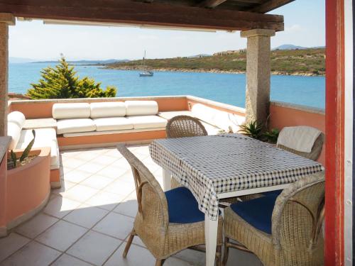 a table and chairs on a balcony with a view of the water at Apartment Ginestra by Interhome in Casa Tamponi