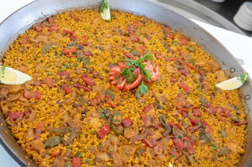 a pan full of food with meat and vegetables at Hotel BCL Levante Club & Spa 4 Sup - Only Adults Recomended in Benidorm