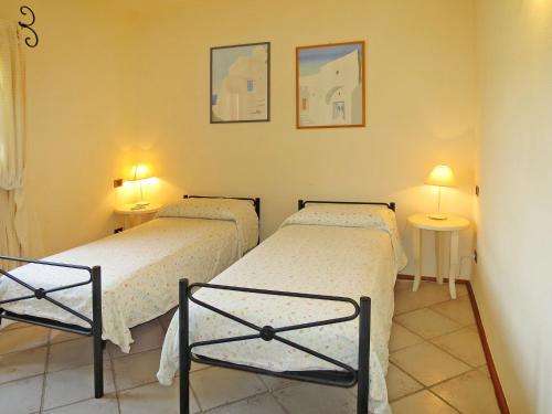 two twin beds in a room with two lamps at Apartment Ginestra by Interhome in Casa Tamponi