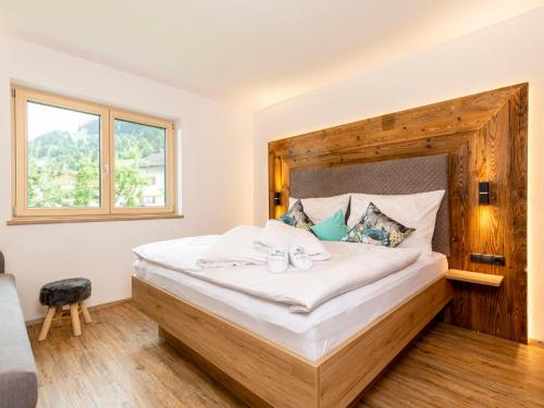a bedroom with a large bed with a wooden headboard at Apartment Apart Jasmin by Interhome in Ramsau im Zillertal