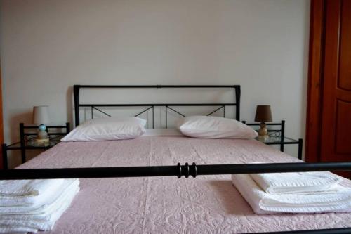 un letto con 2 cuscini bianchi e una struttura nera di Kissamos Serene 3-bedroom Apartment a Kíssamos