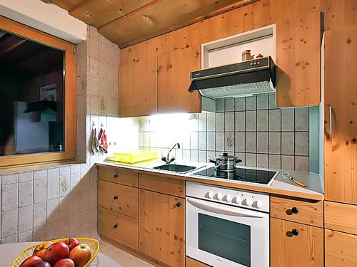 cocina con armarios de madera y horno con fogones en Apartment Ainhauser-2 by Interhome, en Rodund