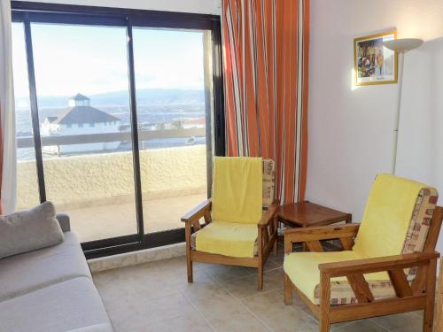 un salon avec un canapé et des chaises et une grande fenêtre dans l'établissement Apartment Coudalère-Guadeloupe-8 by Interhome, au Barcarès