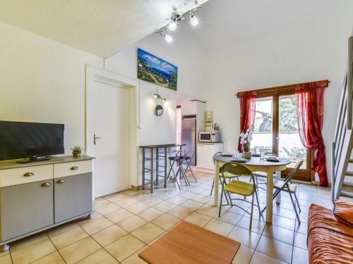 uma cozinha e uma sala de estar com uma mesa e uma televisão em Apartment Les Patios du Barcarès-2 by Interhome em Le Barcarès