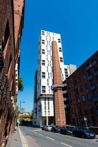 a tall white building on a city street with cars at The Assembly Manchester Oasis Holding in Manchester