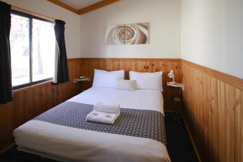 a bedroom with a bed with two towels on it at Sun Country Lifestyle Park in Mulwala
