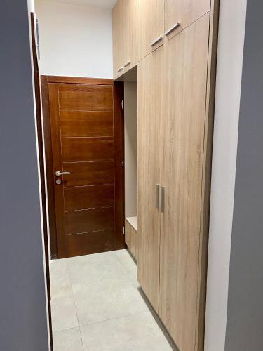 a hallway with wooden cabinets and a door at Villa Dolphin Apartments in Petrovac na Moru