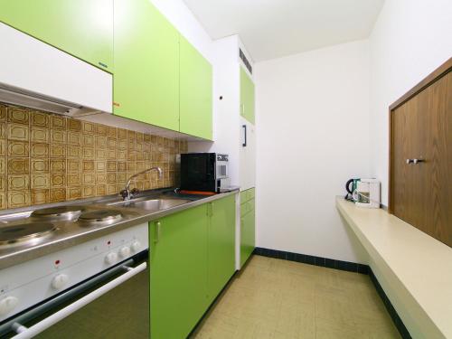 a kitchen with green cabinets and a sink at Apartment Ringstrasse Apt 412 by Interhome in Leukerbad