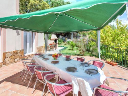 a table with a green umbrella on a patio at Holiday Home Arauco by Interhome in Lloret de Mar