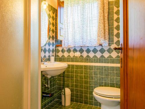 a green tiled bathroom with a toilet and a sink at Holiday Home Cedri Alti-4 by Interhome in Ambra