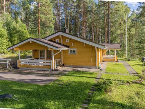 una pequeña cabaña amarilla en medio de un bosque en Holiday Home Konnusmaja by Interhome, en Leppävirta