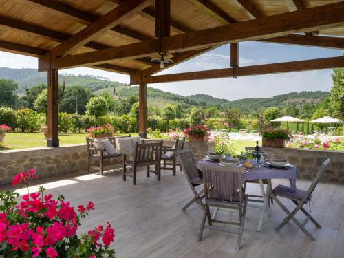 une terrasse avec une table et des chaises sous une pergola en bois dans l'établissement Holiday Home Santa Lucia by Interhome, à Castiglion Fiorentino
