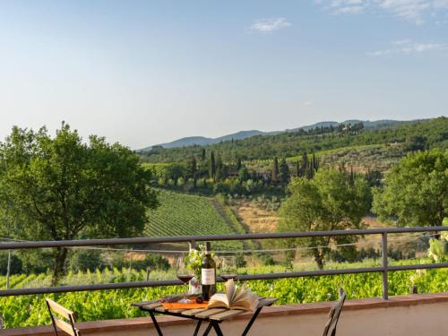 una mesa con una copa de vino en el balcón con vistas a un viñedo en Holiday Home Casa 360 by Interhome, en Greve in Chianti