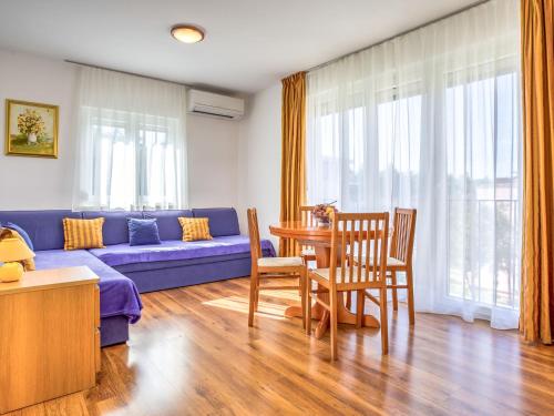 a living room with a blue couch and a table at Apartment File-5 by Interhome in Zambratija