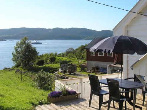 une terrasse avec une table, des chaises et un parasol dans l'établissement Holiday Home Soltun - FJH633 by Interhome, à Flygansvær