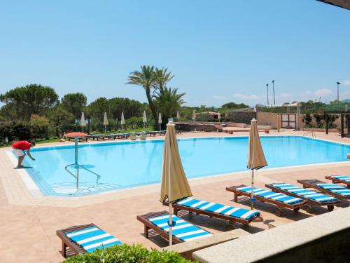 una piscina con sedie a sdraio e ombrelloni di Apartment Il Borgo - PCR215 by Interhome a Villaputzu