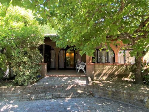 a house with a porch with a chair on a patio at Apartment Gufo-11 by Interhome in Podere Dottrina