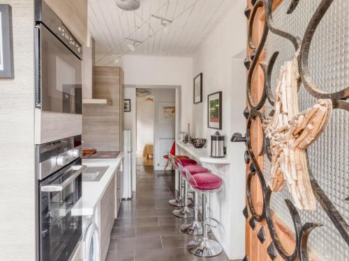 - une cuisine avec des tabourets rouges et un mur avec un miroir dans l'établissement Apartment Villa Giroflé by Interhome, à Arcachon