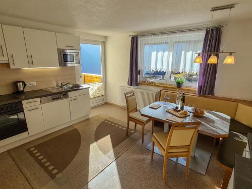 kuchnia i jadalnia ze stołem i krzesłami w obiekcie Apartment Alpenliebe-3 by Interhome w mieście Kappl