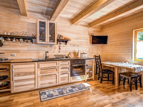 a kitchen with wooden walls and a table and chairs at Chalet Plitvice II by Interhome in Rudanovac