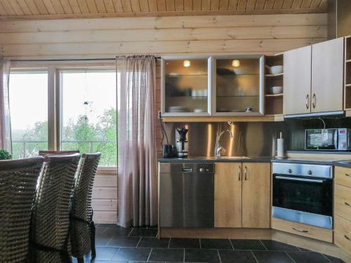 une cuisine avec des placards en bois et une grande fenêtre dans l'établissement Holiday Home Haltinsaana by Interhome, à Kilpisjärvi