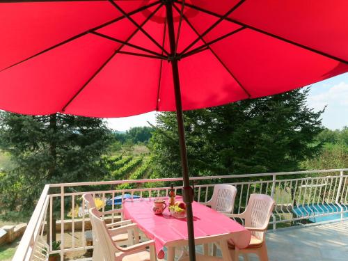 a red umbrella on a table with two dolls on it at Apartment Mirjana - LBN312-2 by Interhome in Ružići