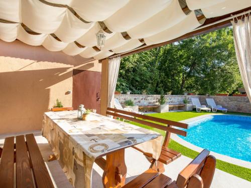 Dobrinj的住宿－Holiday Home Mikac - MLK136 by Interhome，一个带桌椅的庭院和一个游泳池