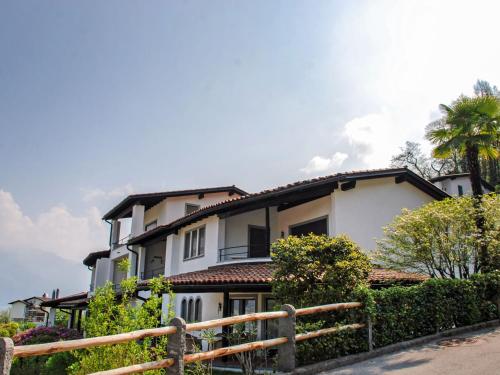 a white house with a fence in front of it at Apartment Residence Miralago - Utoring Apt- A9 by Interhome in Piazzogna