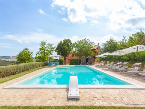 une grande piscine avec des chaises et des parasols dans l'établissement Apartment I Due Carpini-3 by Interhome, à Citta' Sant'Angelo