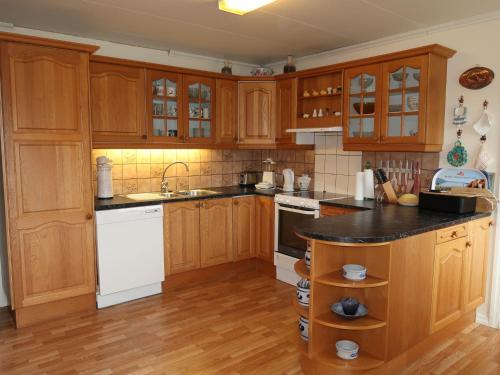 a kitchen with wooden cabinets and a black counter top at Holiday Home Gule huset by Interhome in Bruntveit