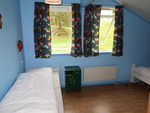 a bedroom with blue walls and a bed and a window at Holiday Home Gule huset by Interhome in Bruntveit