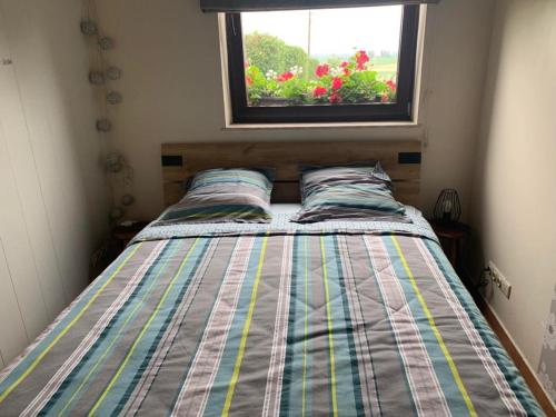 Cama en habitación pequeña con ventana en A l'orée du Bois, en Landelies