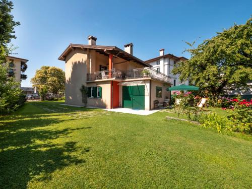 une maison avec une pelouse verte devant elle dans l'établissement Holiday Home Casa Con Le Rose by Interhome, à San Daniele del Friuli