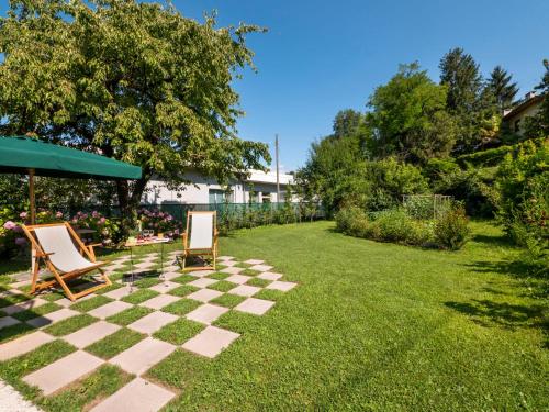 einen Rasen mit zwei Stühlen und einem Schachbrett in der Unterkunft Holiday Home Casa Con Le Rose by Interhome in San Daniele del Friuli