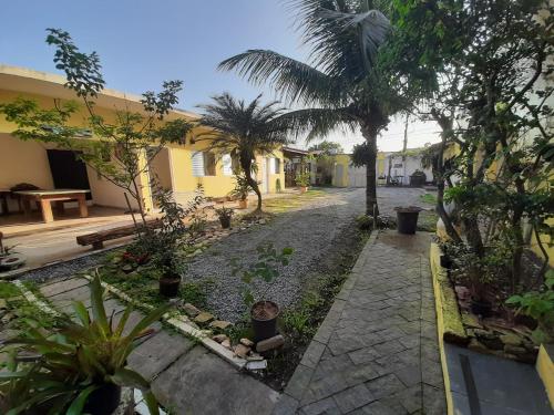 a courtyard with palm trees and a building at PousadaRecanto684Guarujá in Guarujá