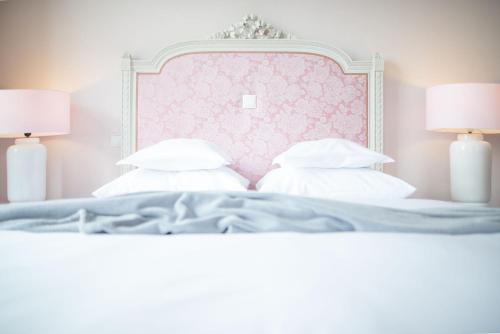 Schlafzimmer mit einem Bett mit einem rosa Kopfteil und Kissen in der Unterkunft Hotel Bamberger Hof Bellevue in Bamberg