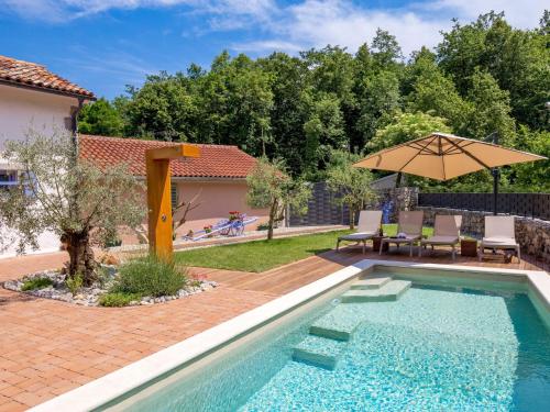 a swimming pool with a patio and an umbrella at Holiday Home Villa Antonio by Interhome in Jurdani