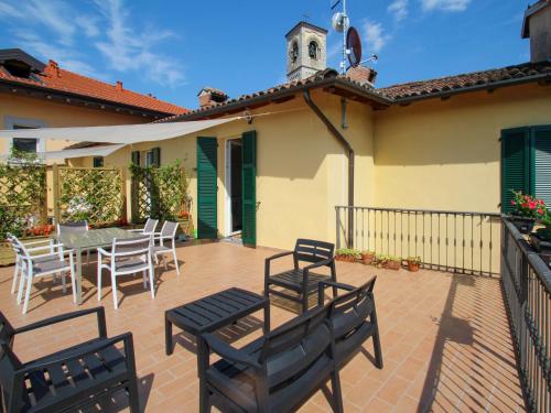 een patio met stoelen en een tafel en een vogelhuisje bij Apartment Atmosfere sul lago by Interhome in Porto Valtravaglia