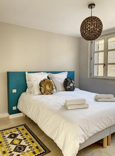 un grand lit blanc avec deux oreillers dessus dans l'établissement Les Estrelles, à Saint-Rémy-de-Provence