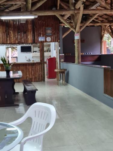 a table and a white chair in a room at Recanto R-12 in Rodeio Doze
