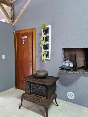 a room with a table with a stove in front of a fireplace at Recanto R-12 in Rodeio Doze
