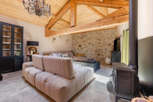 a living room with a couch and a tv at Maison Melanie - Superbe Chalet proche des pistes in Les Angles