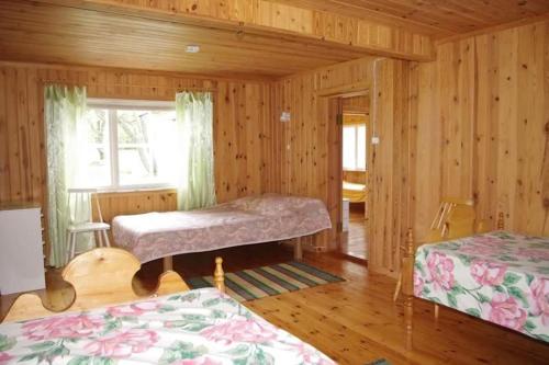 a bedroom with two beds in a wooden room at Sepa Jõe Holiday Home in Riksu