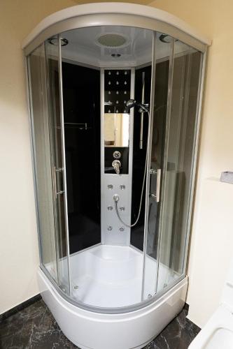 a shower with a glass enclosure in a bathroom at Penzión Deloris in Trenčín