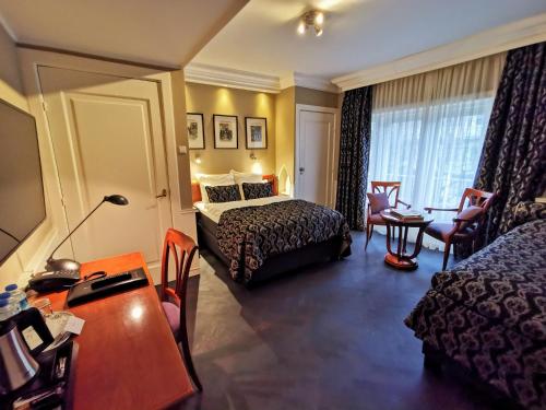 Cette chambre comprend un lit et un bureau. dans l'établissement Apollofirst Boutique Hotel, à Amsterdam